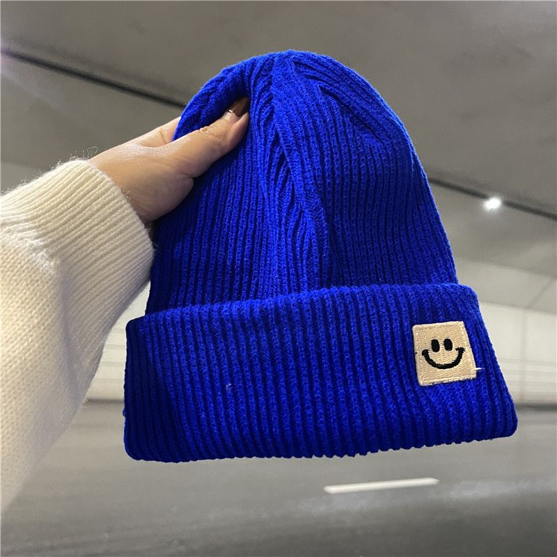 Cara sonriente de punto, gorro de lana, linda tendencia de otoño e invierno, protección auditiva versátil, aislamiento negro, hombre_voghion.com