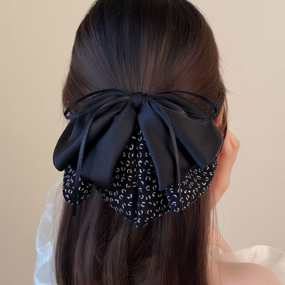 Nouvelle pince à cheveux en satin ornée d'un camélia et de perles. Son nœud raffiné rehausse le volume des cheveux et apporte une touche d'élégance à la queue de cheval._voghion.com