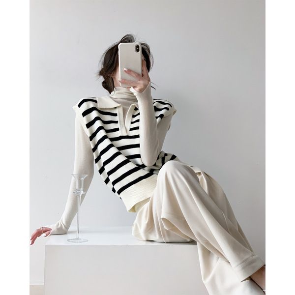 To go to the brightly lit, milky white background with black stripes neatly layered on a V-neck knitted vest vest